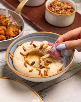 Delicious hummus topped with pine nuts and served with freshly baked pita.