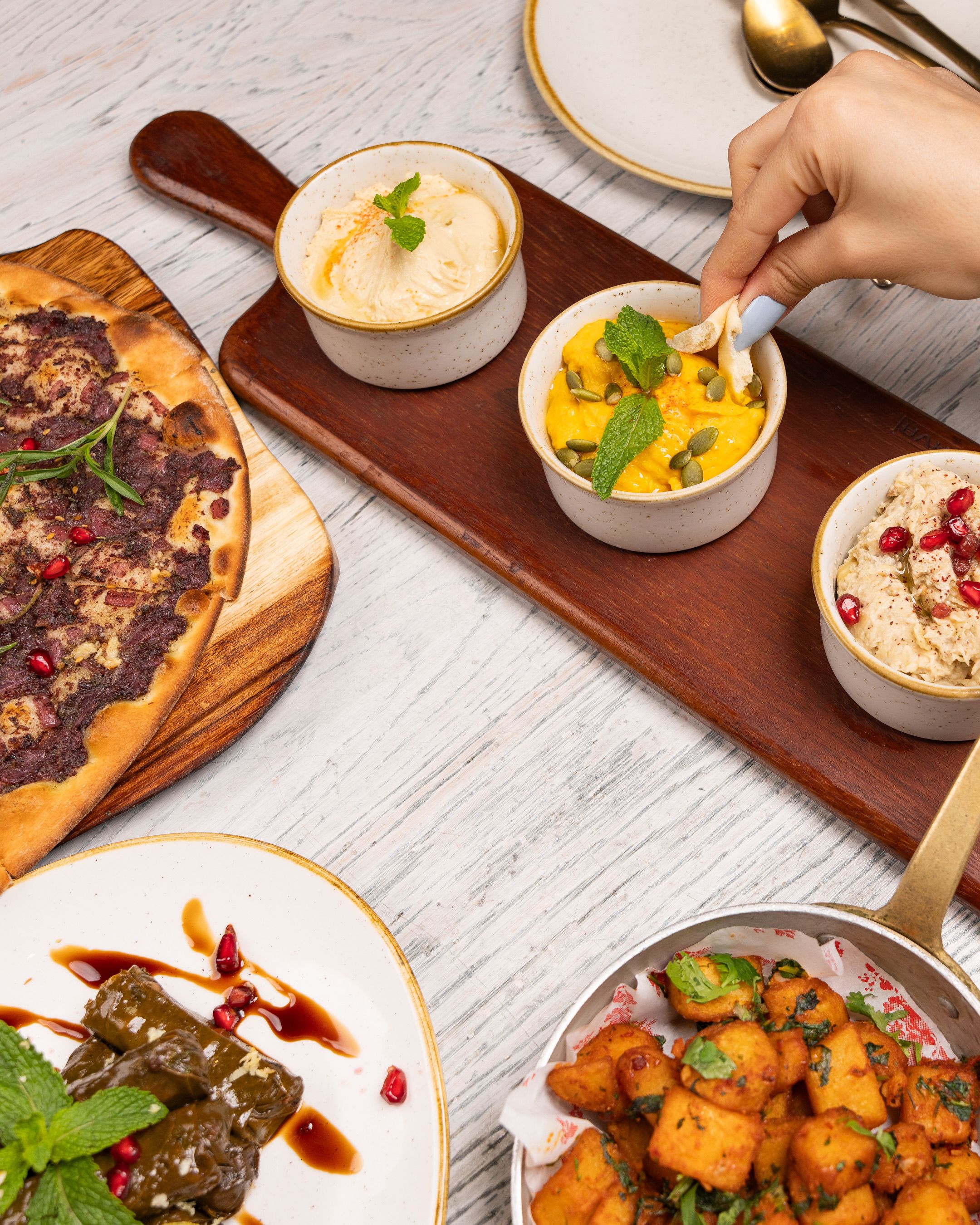 An enticing spread of Mediterranean dishes including flatbread and assorted dips, ideal for dining concepts.