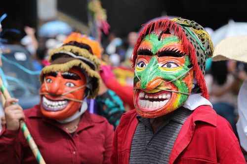 Free Colorful masks and costumes at a lively festival parade in San Salvador. Stock Photo