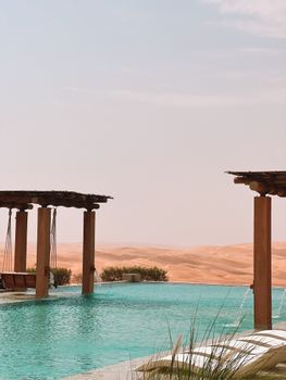 Tranquil infinity pool amidst the serene desert sands of UAE for ultimate relaxation.