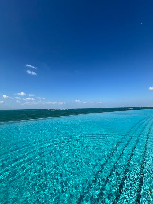 A pool with blue water and a view of the ocean
