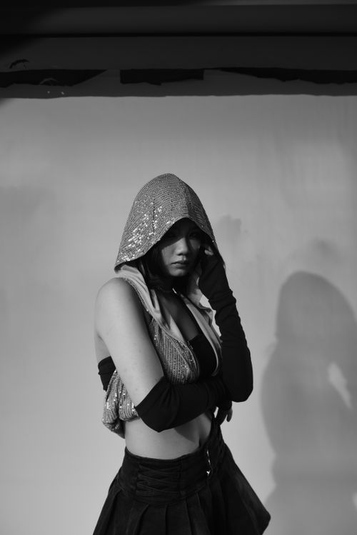 Free Captivating black and white fashion portrait of a woman posing with a hood in a studio setting. Stock Photo