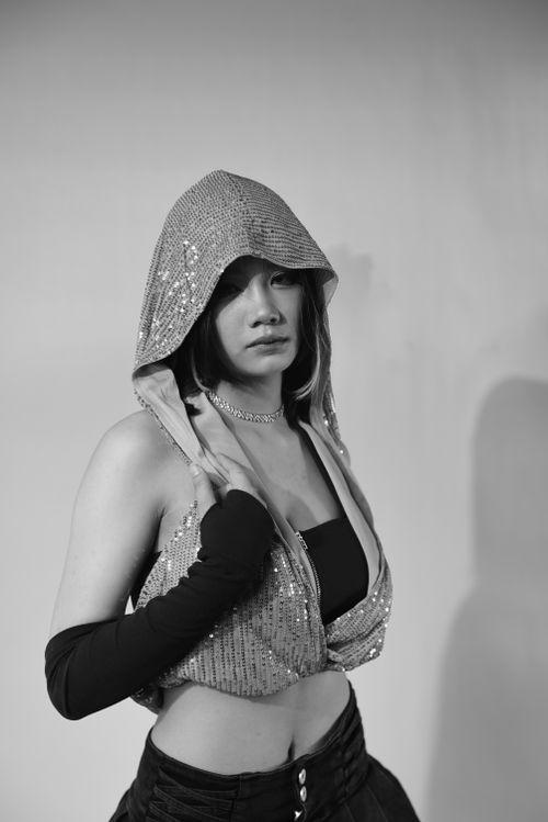 Free Elegant woman modeling a hooded top in a stunning black and white studio portrait. Stock Photo