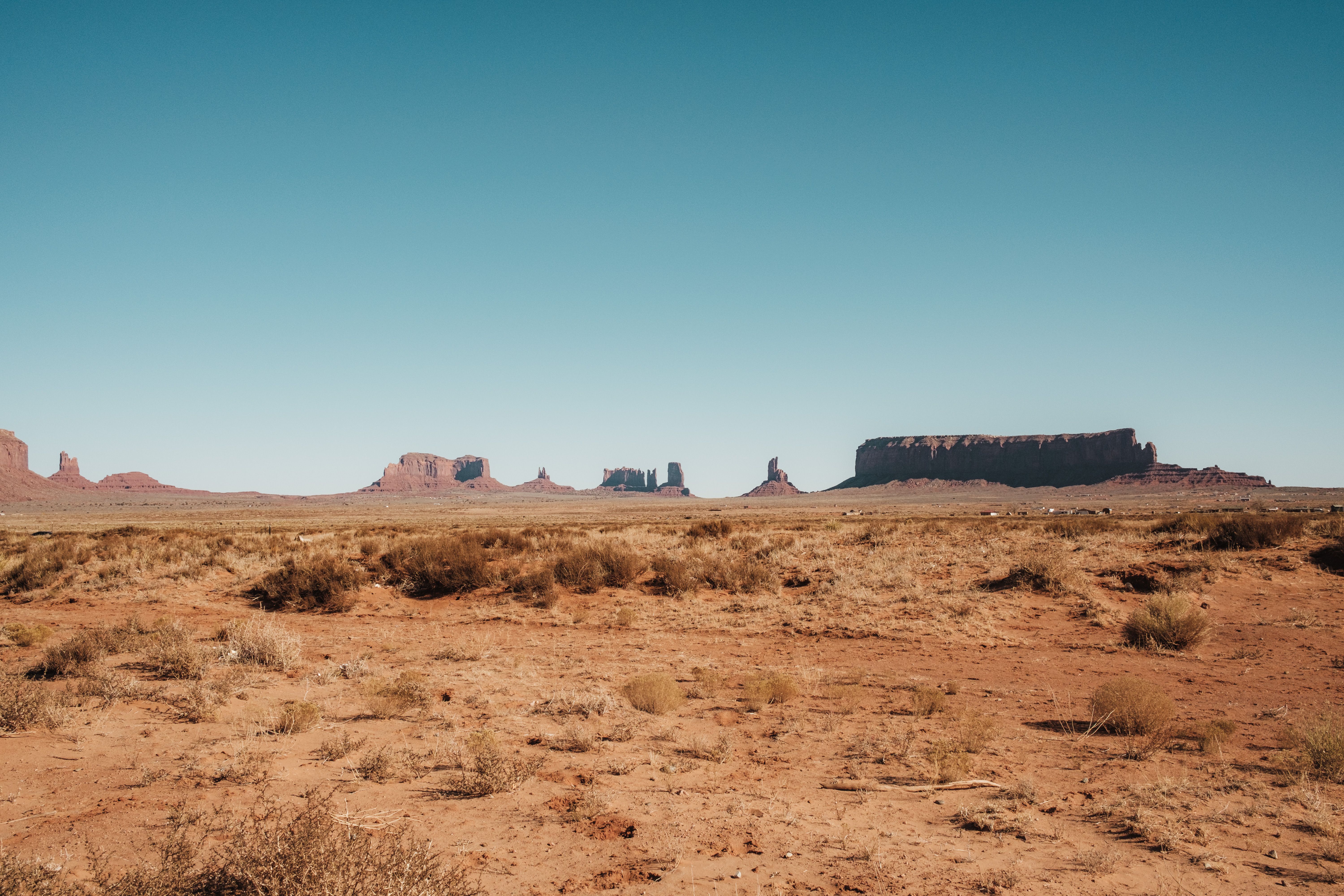 A desert landscape with a few rocks and a few trees · Free Stock Photo