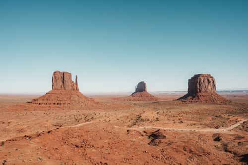 Free Explore the majestic buttes of Monument Valley under a clear, blue sky, capturing the essence of the American Southwest. Stock Photo