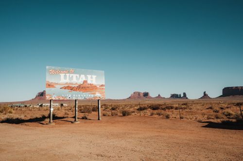 Free Explore the arid beauty of Monument Valley with the iconic Utah welcome sign under a clear sky. Stock Photo