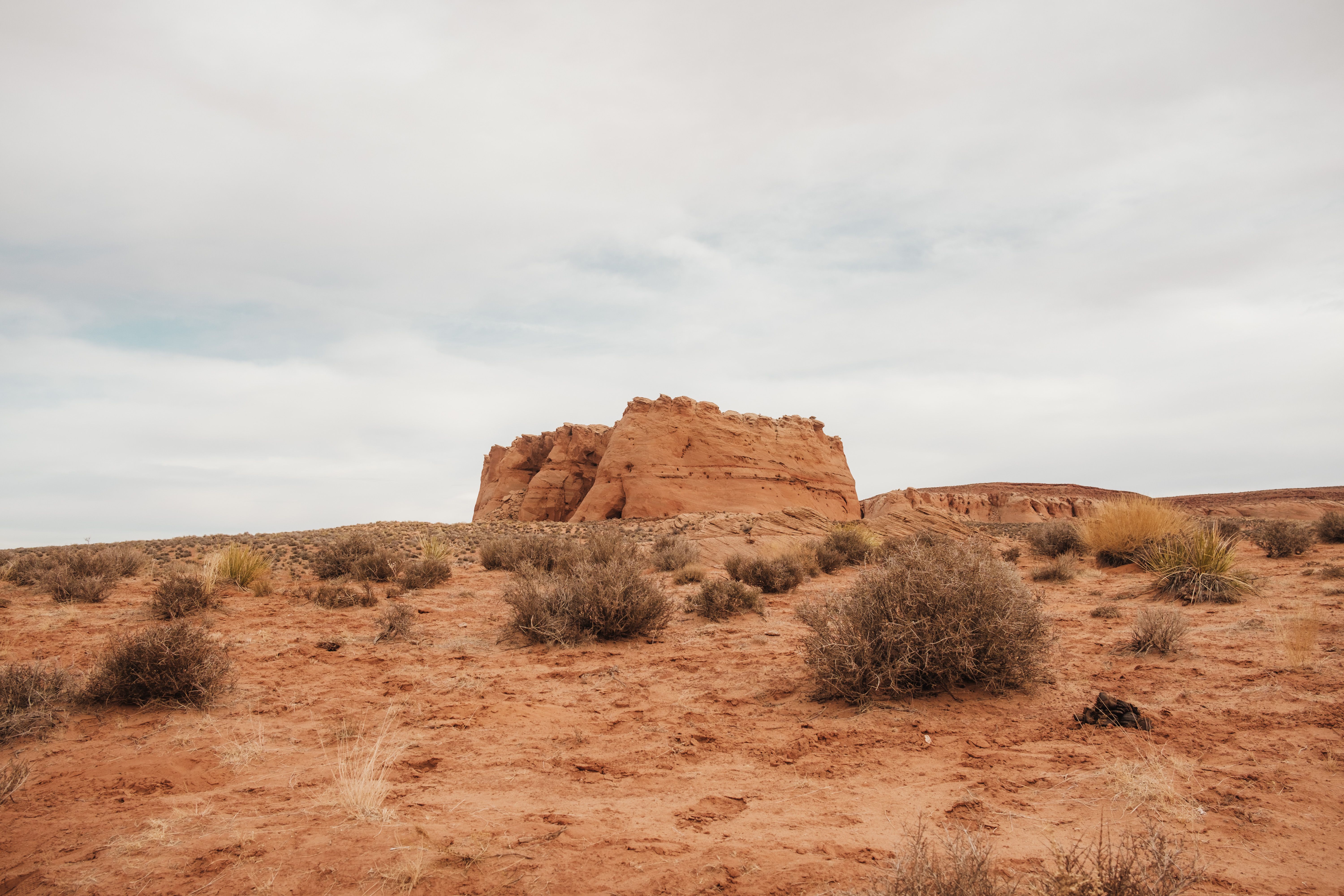 A desert landscape with a large rock formation · Free Stock Photo