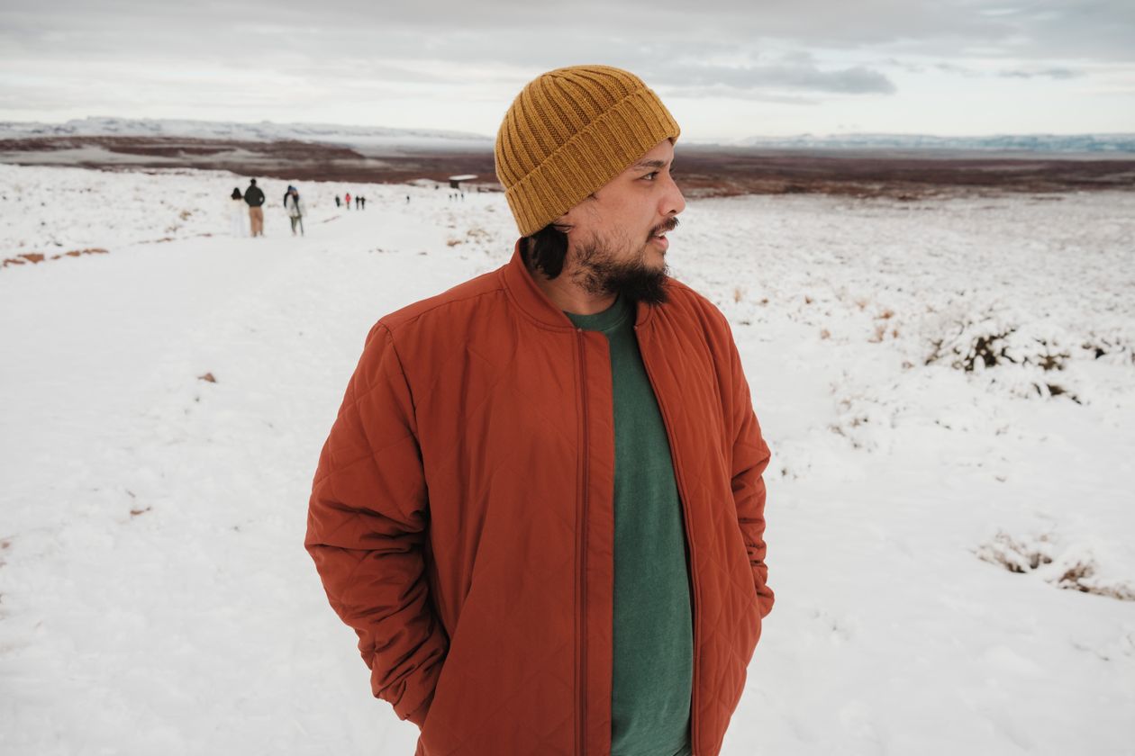 Person in winter coat looking at snowy landscape