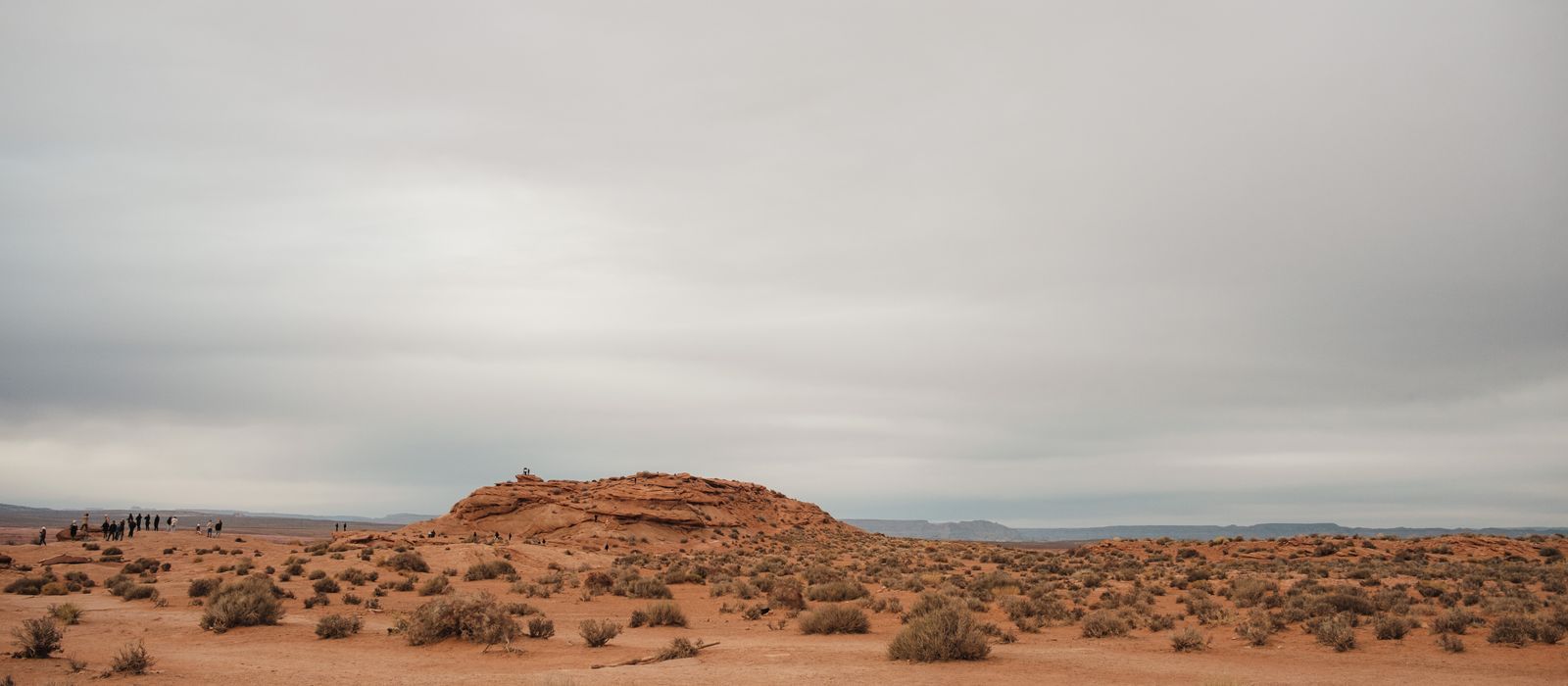 A cloudy desert landscape near Page, Arizona, showcasing rocky formations and sparse vegetation.