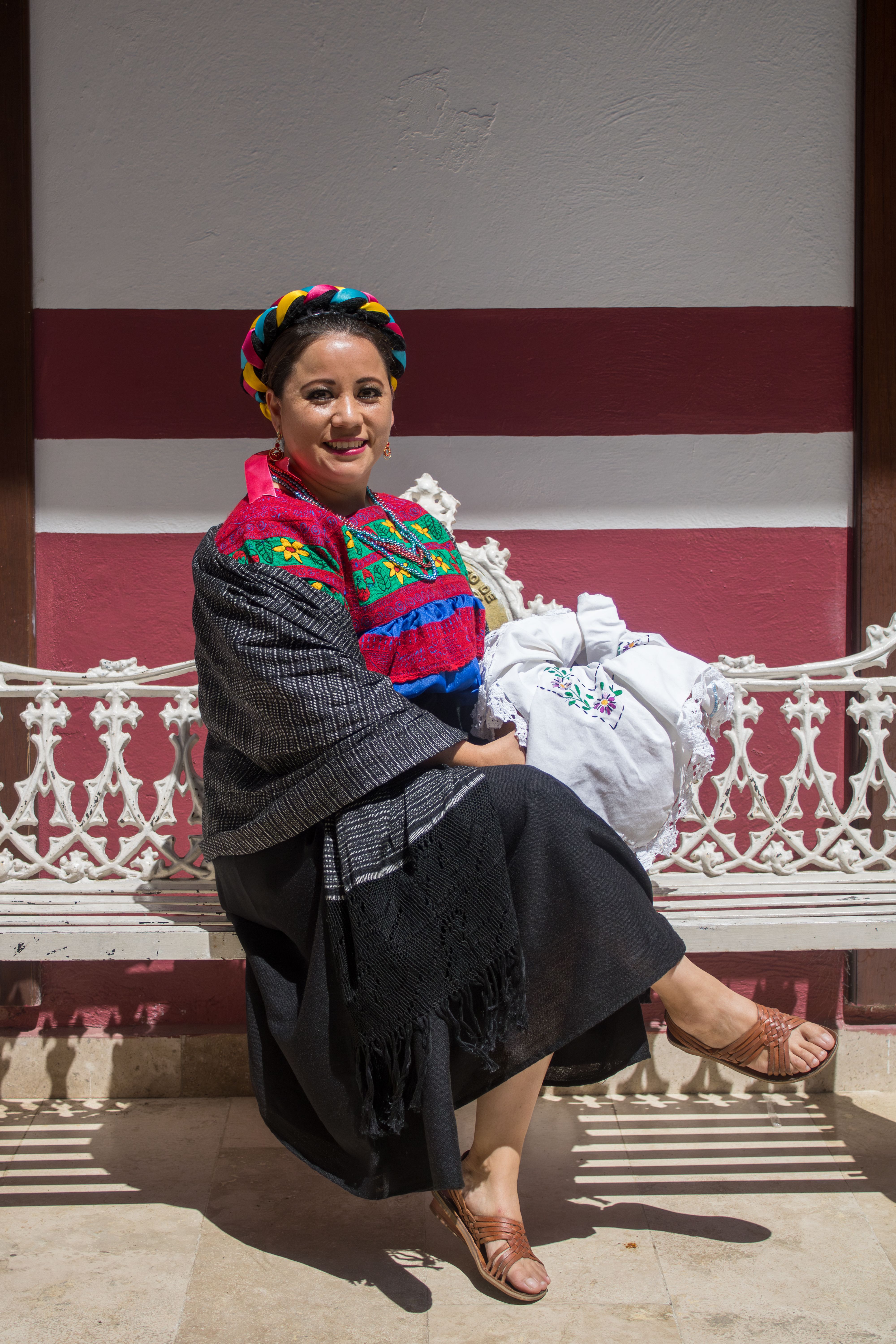 A woman in traditional clothing sitting on a bench · Free Stock Photo