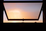 日落时分，温暖的阳光透过敞开的窗户洒进来，营造出宁静的氛围