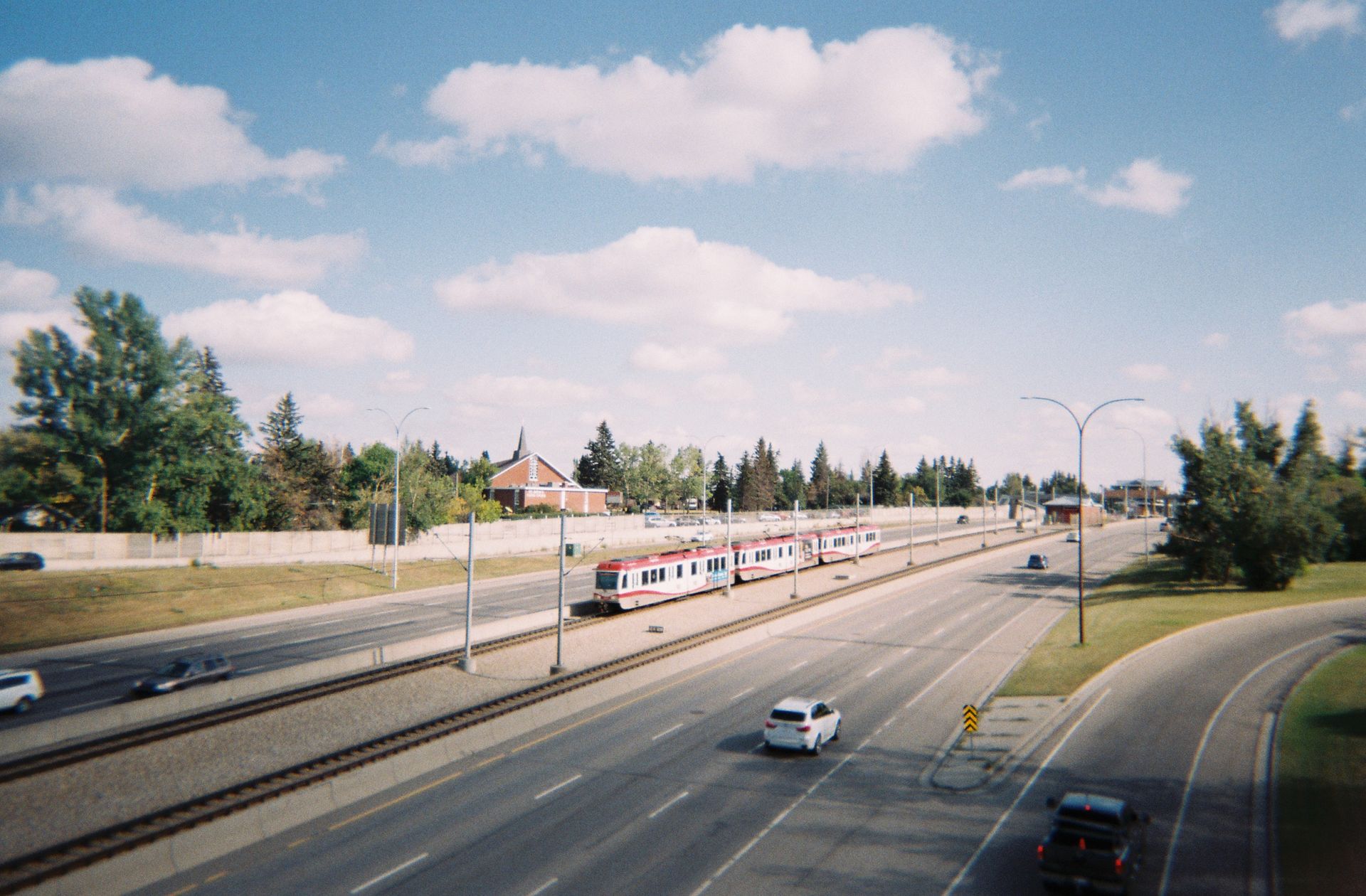 A vibrant view of a highway and train in Calgary, Alberta, Canada during a sunny day.