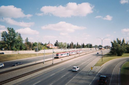 Free A vibrant view of a highway and train in Calgary, Alberta, Canada during a sunny day. Stock Photo