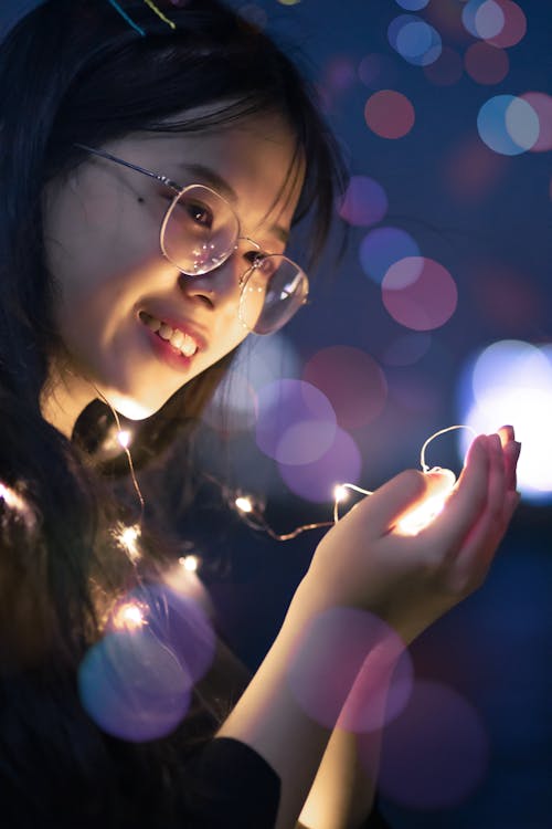 Woman Holding Lighted String Lights