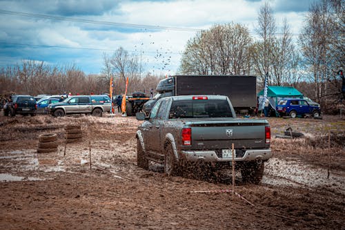 A truck driving through mud in a field