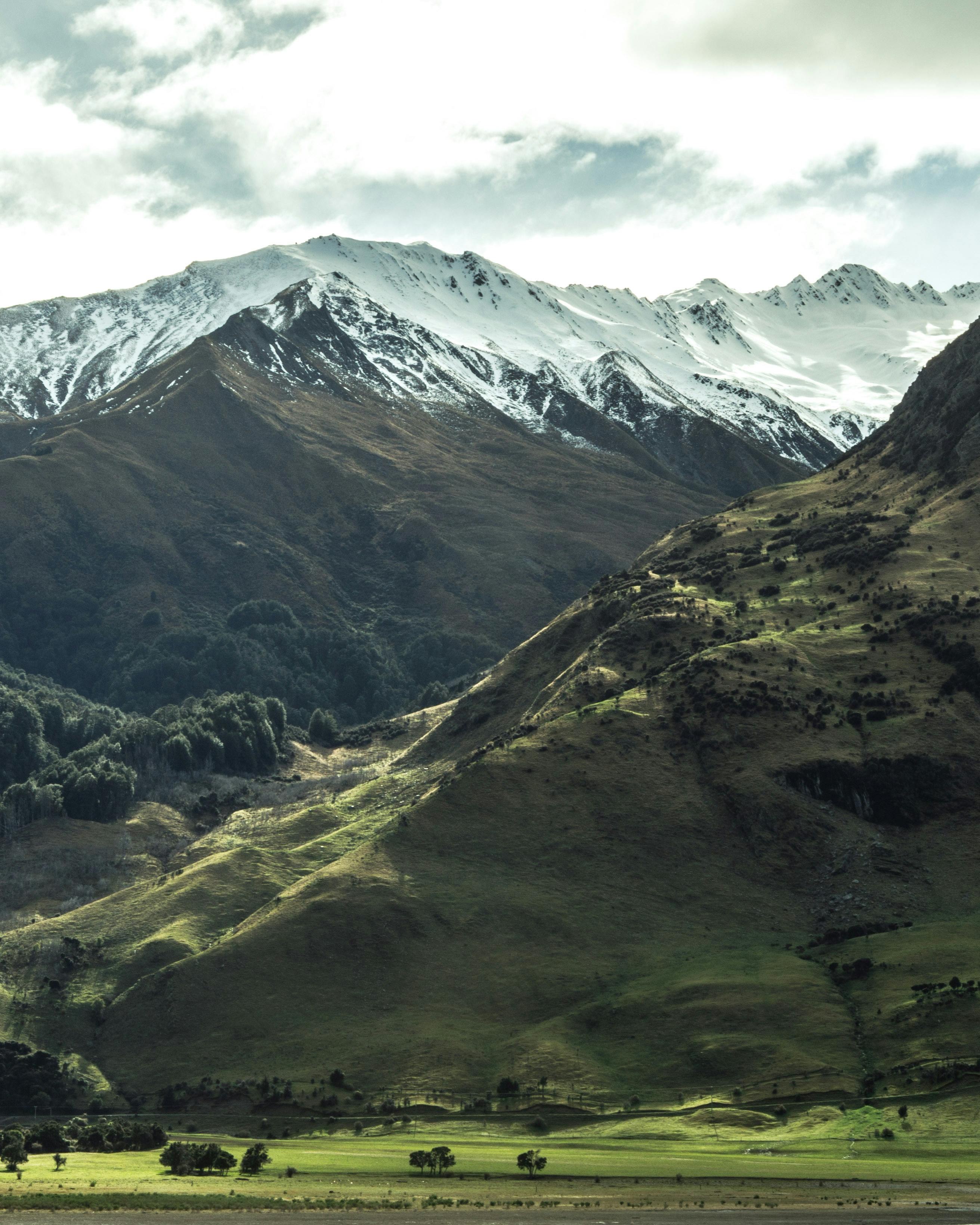 白雪皑皑的山脉与郁郁葱葱的绿色山谷，在宁静的风景中令人惊叹