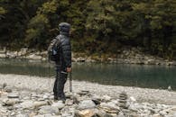 徒步旅行者在宁静的河边，进行了一场冬季大自然冒险