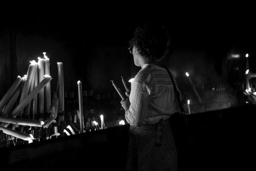 Free A woman lights candles in a spiritual setting in Fatima, Portugal. Stock Photo