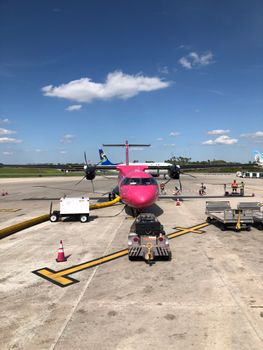 Colorful plane parked on a sunny day at Orlando International Airport runway.