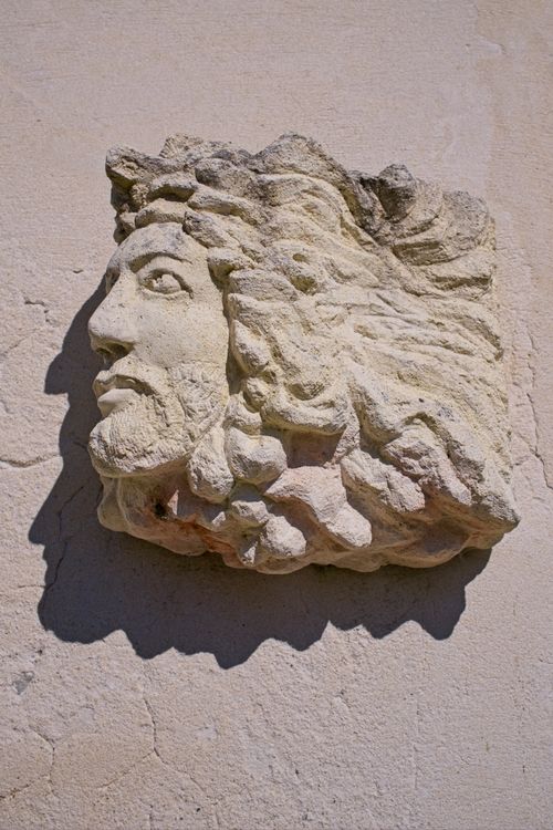 Free A detailed limestone carving of a bearded king's head on a wall, showcasing classic artistry. Stock Photo
