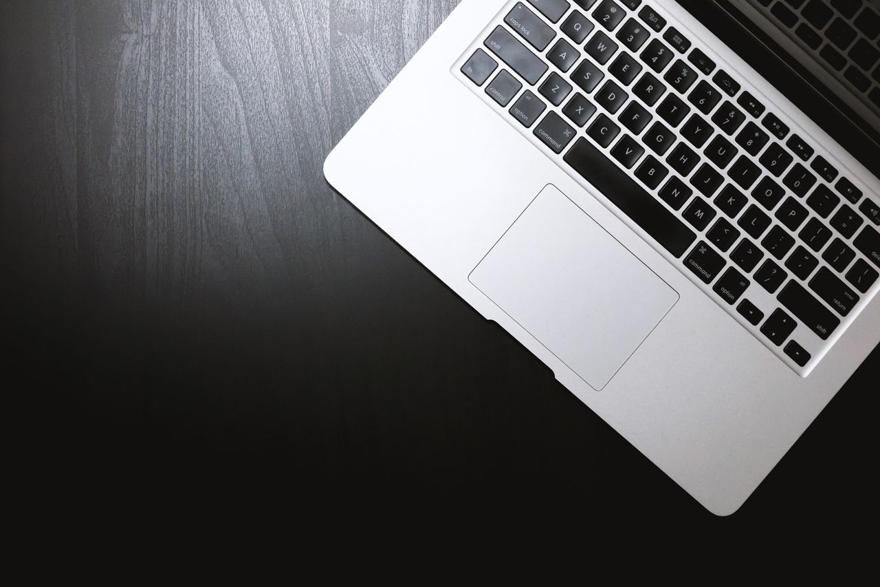 top view of a sleek laptop on a dark wooden desk showcasing modern tec