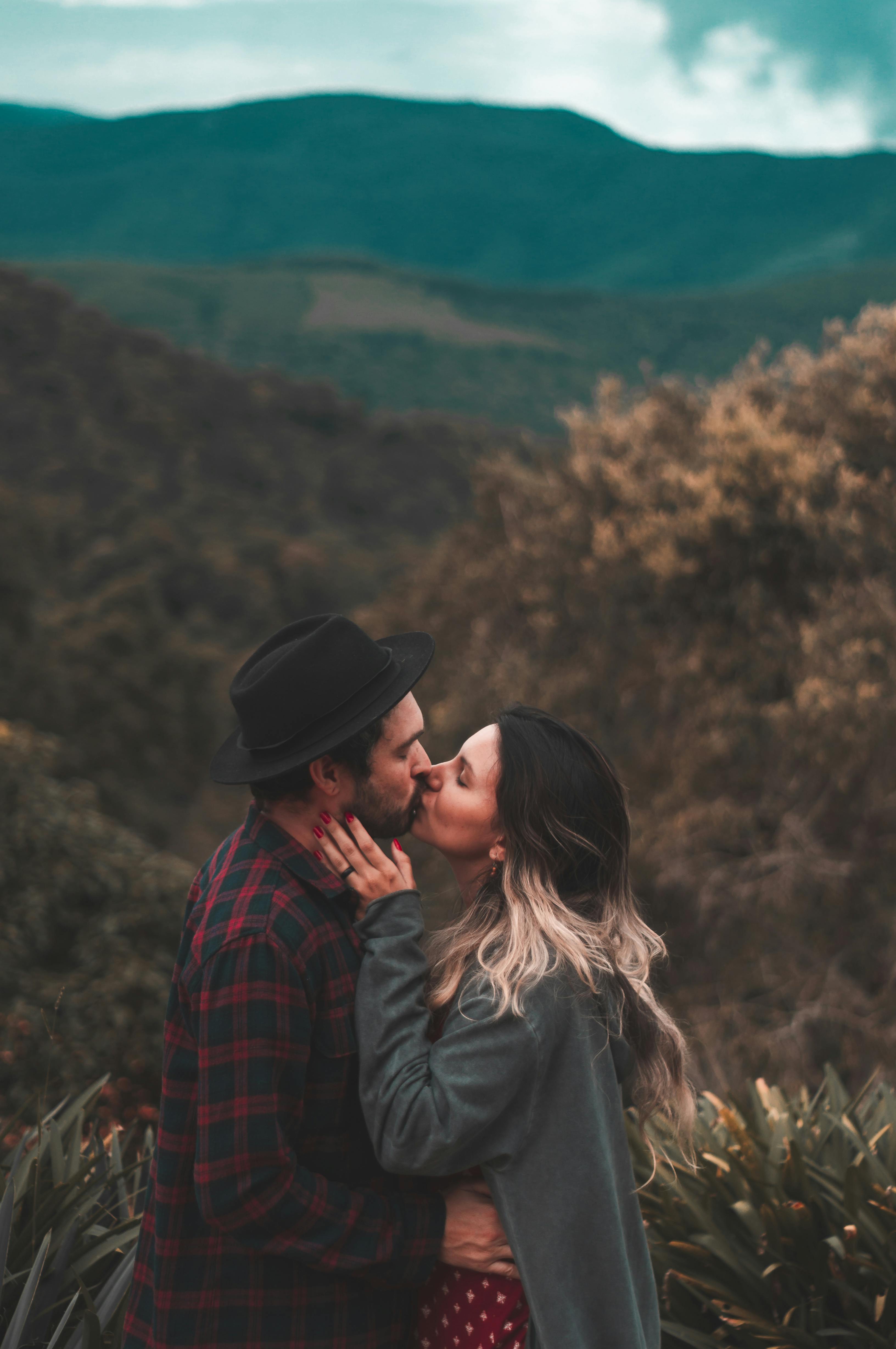 男と女が茶色の木の近くでキス 無料の写真素材