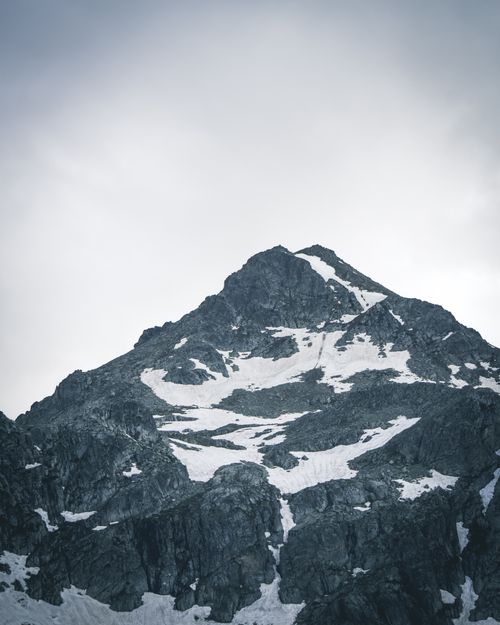 Free Majestic snow-capped mountain peak standing tall under a cloudy sky, showcasing winter's serene beauty. Stock Photo