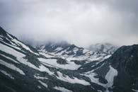 雪山景观令人惊叹，山峰笼罩在重重迷雾之中，雪地星罗棋布