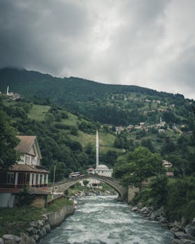 风景如画的景色包括历史桥梁和清真寺，它们坐落在郁郁葱葱的山谷中，旁边有河流流淌