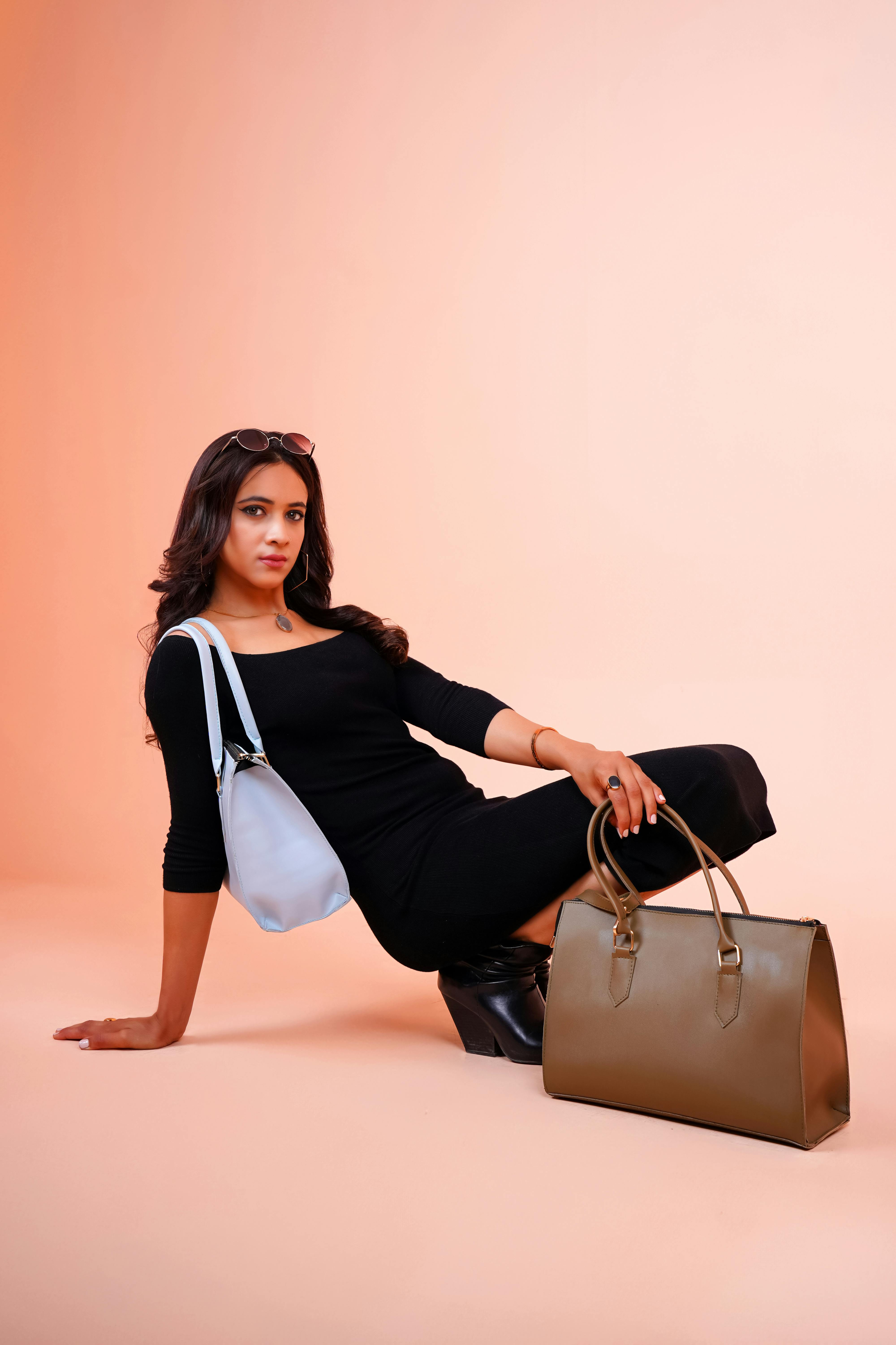 studio shot of an elegant woman posing with bags