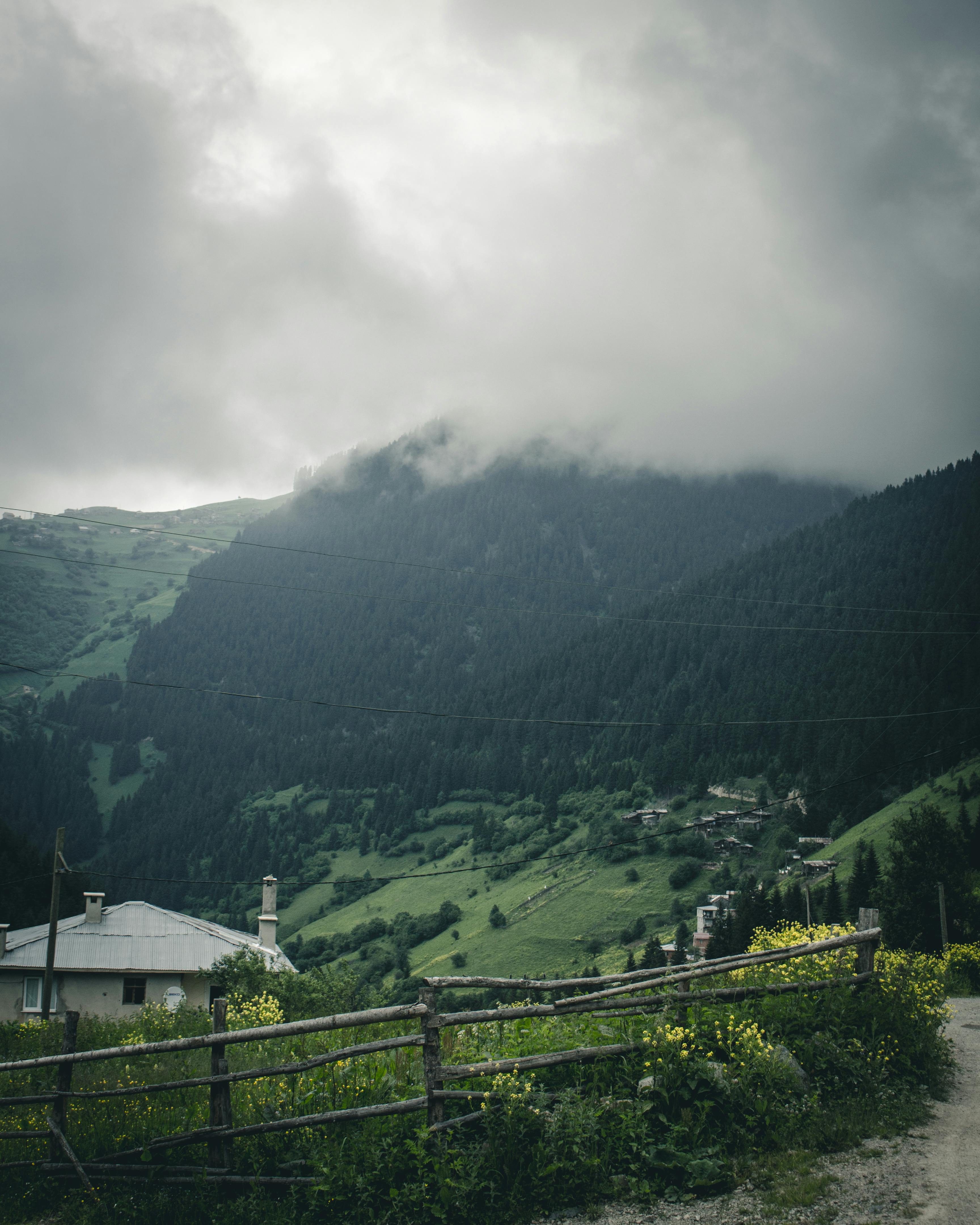 在多云的天空下，雾蒙蒙的山脉和乡村构成了一片风景