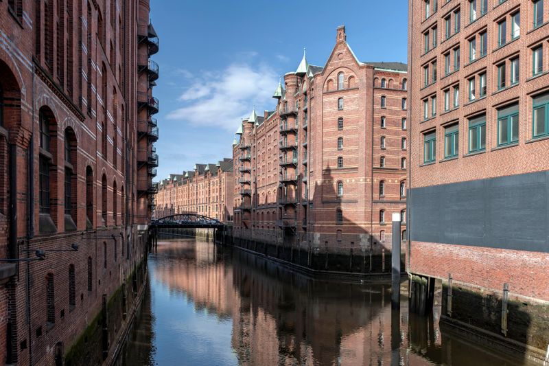 Brick warehouses line the canal in the historic Speicherstadt district of Hamburg, Germany.