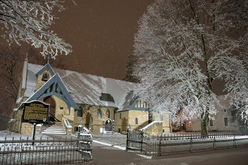 A church is lit up at night with snow on the ground