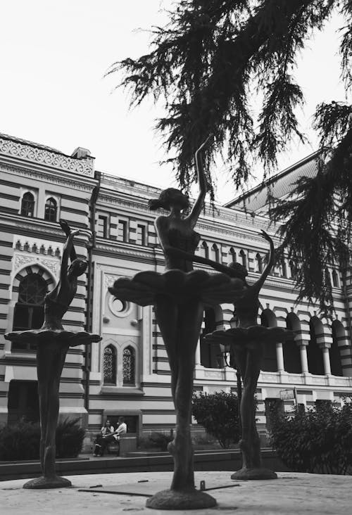 Black and white photo of a fountain in front of a building