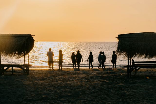 Guests spill out of the cotillion onto the shoreline at dusk — photo by Ella Ragasa on Pexels