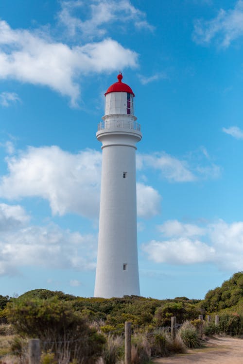 Lighthouse against Blue Sky with Fluffy White Clouds