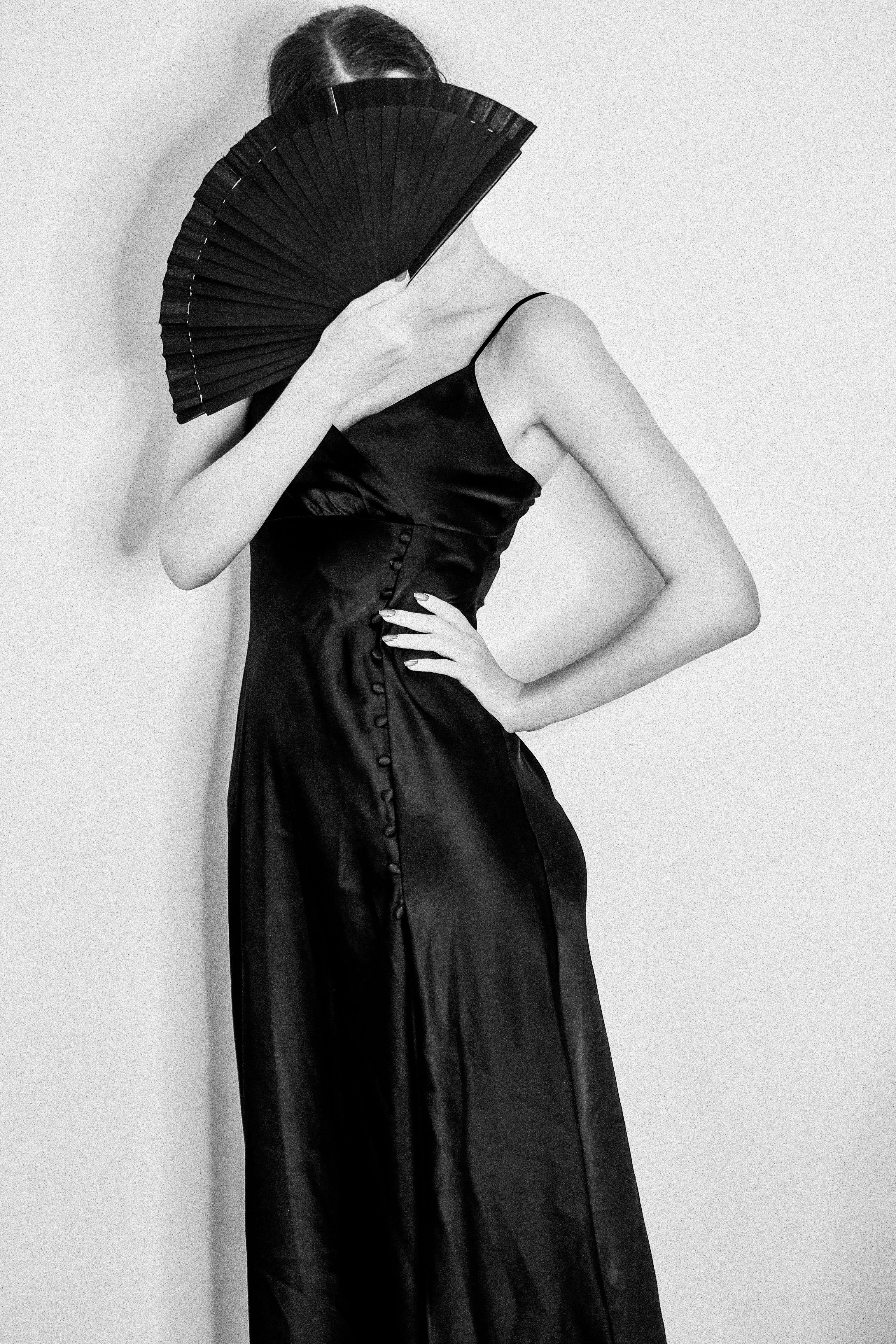 Black and White Photo of a Woman Wearing a Black Dress and Covering Her ...