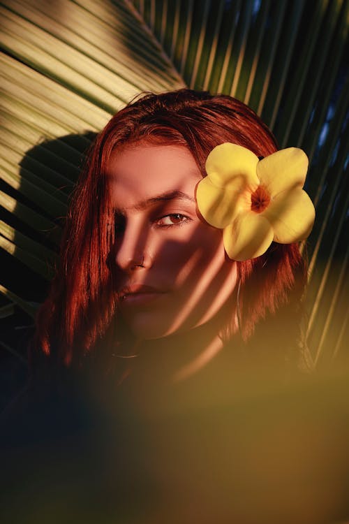 A woman with red hair and a flower in her hair