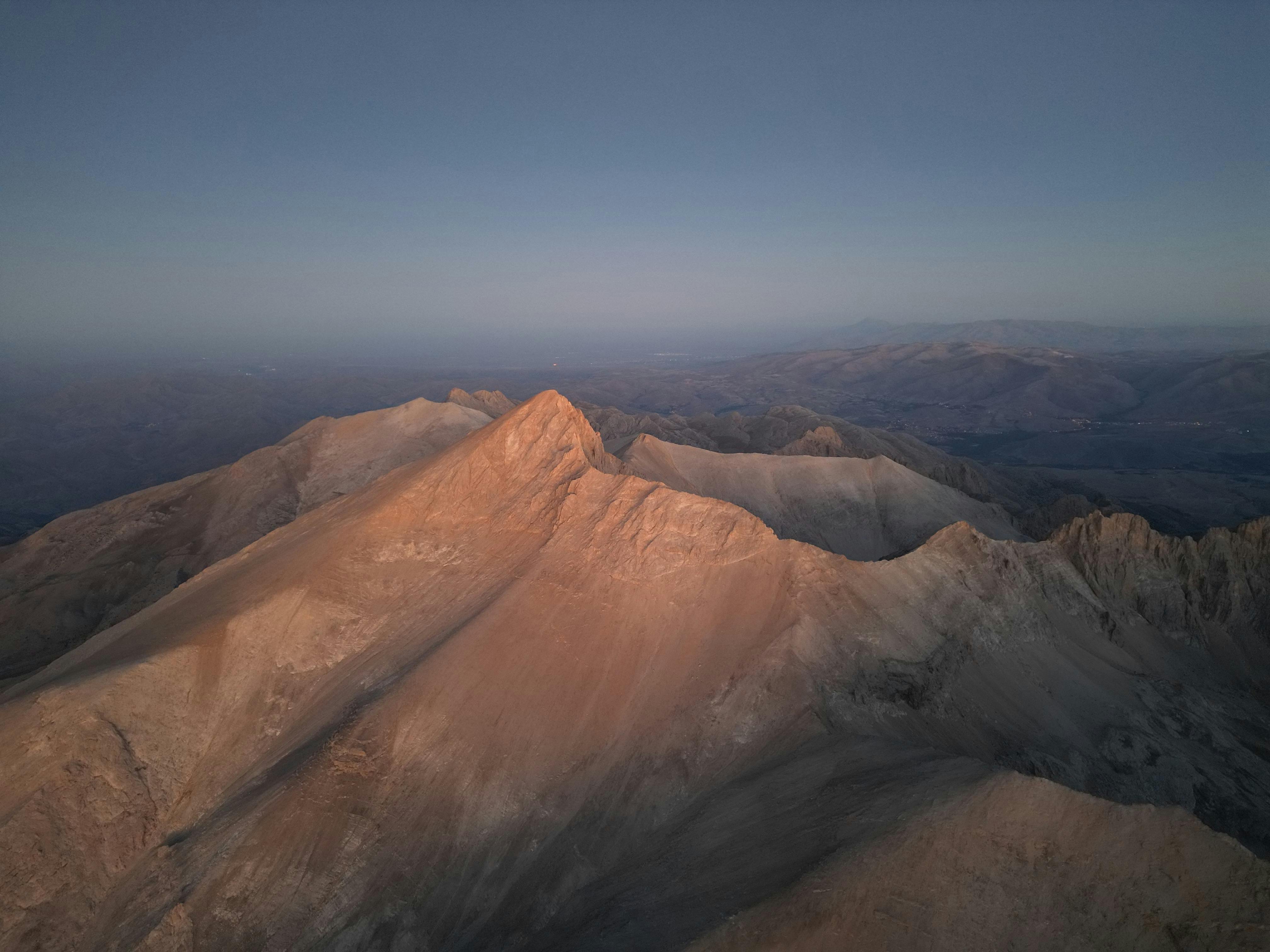 Stunning aerial view of Demirkazık Mountain at dawn with soft muted tones.