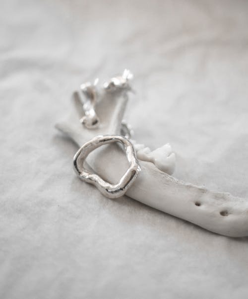 A silver bracelet with a silver ring on it