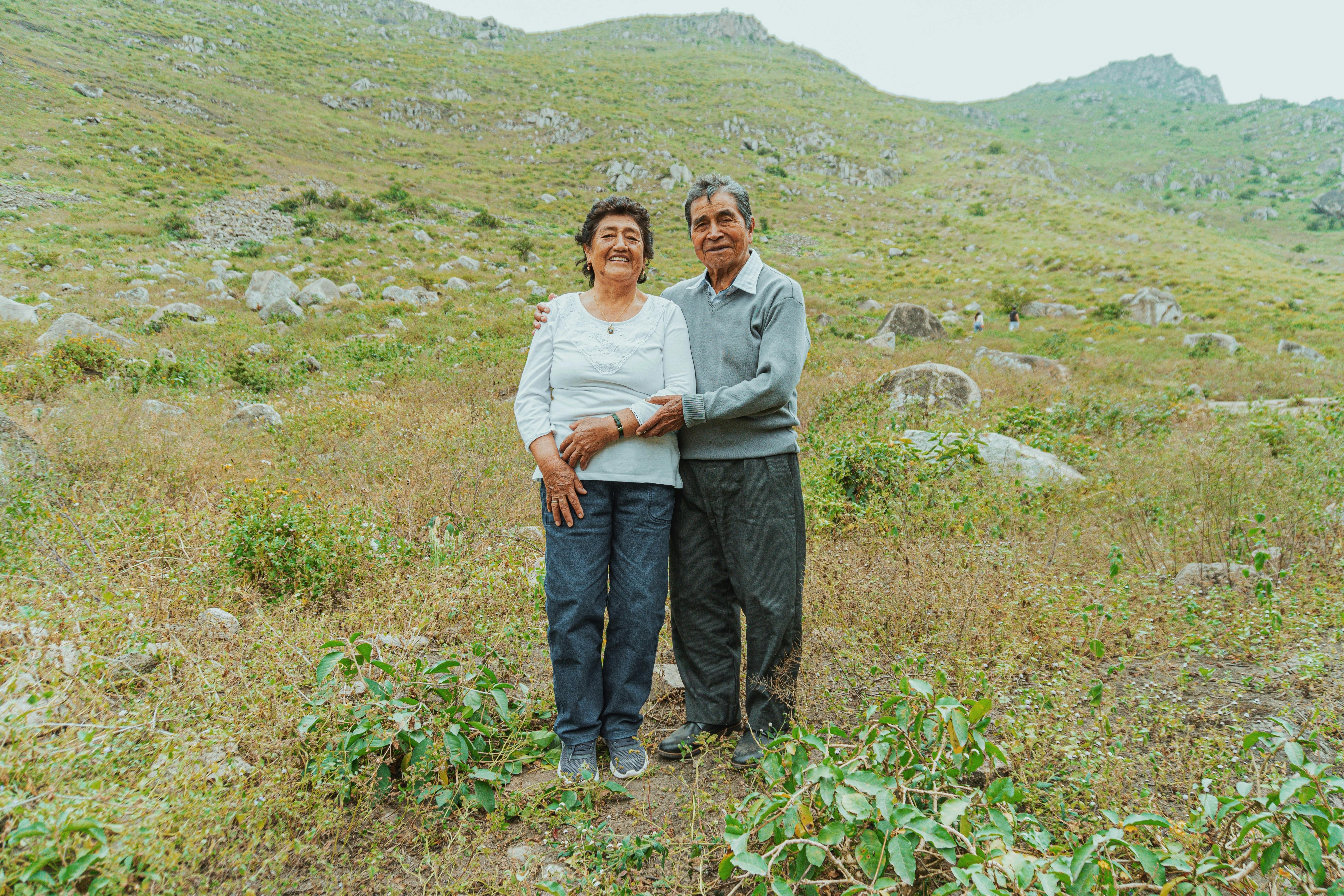 Senior couple embracing amidst a beautiful mountainous landscape, conveying love and togetherness.
