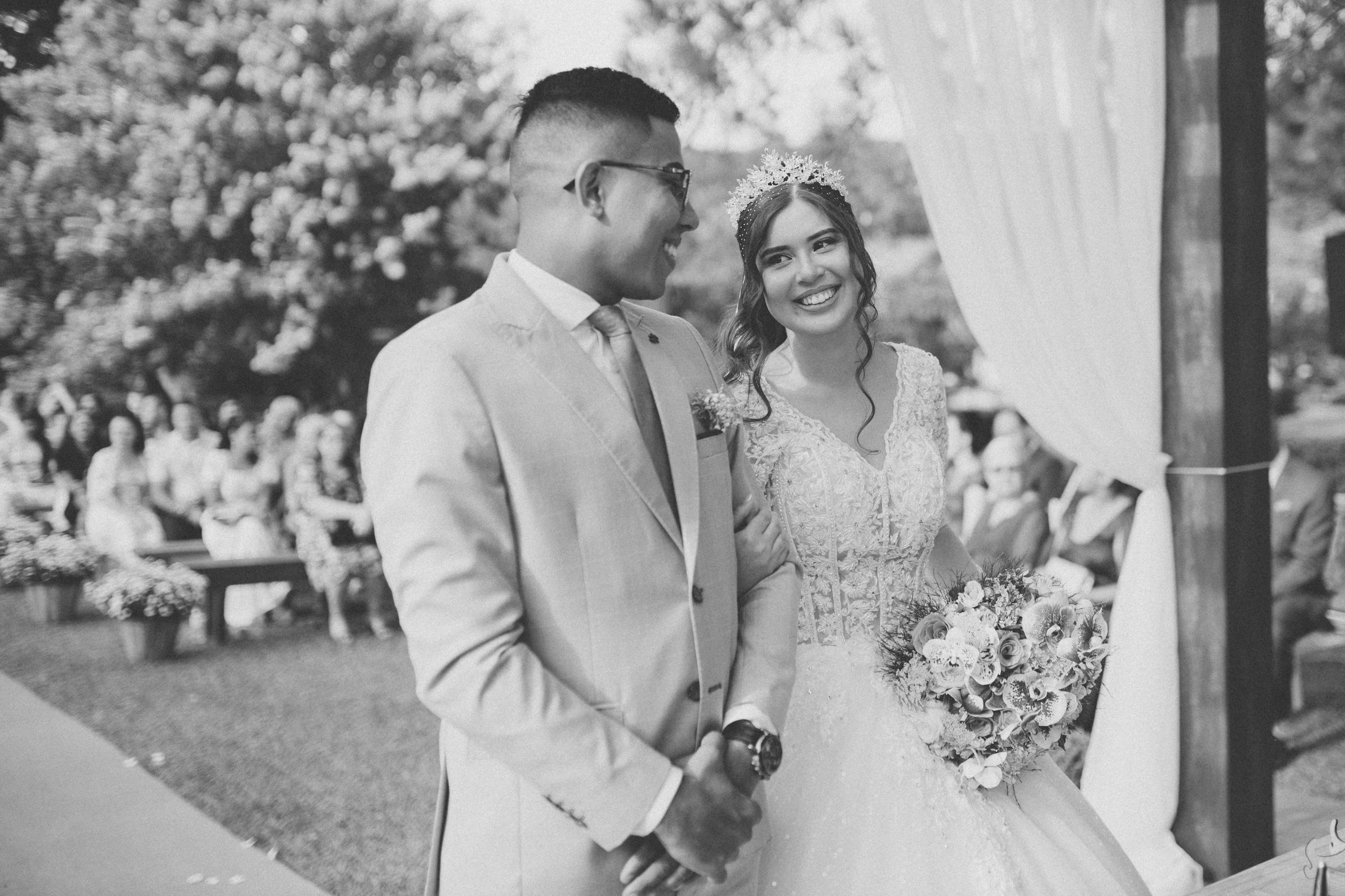 Black and white photo of a joyful couple during an outdoor wedding in Brazil.