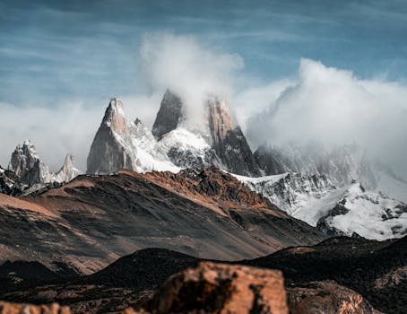 Breathtaking view of Mount Fitz Roy shrouded in clouds, showcasing Patagonia's rugged beauty.