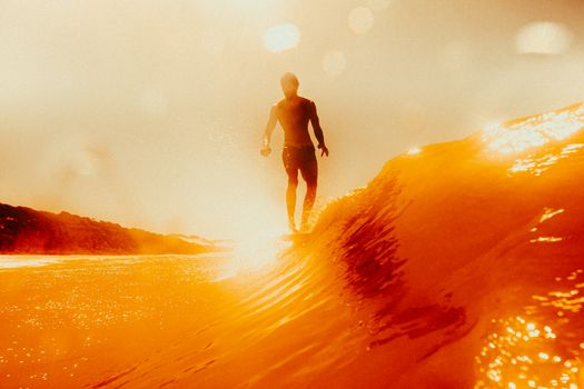 A surfer rides a vibrant wave under an orange sunset in Pipa, Brazil, capturing the essence of adventure.