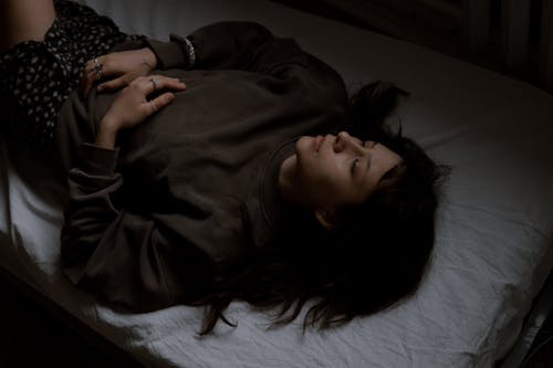 A woman laying on a bed with her eyes closed