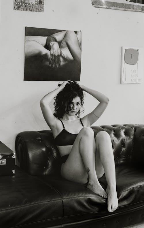 A woman in underwear sitting on a couch