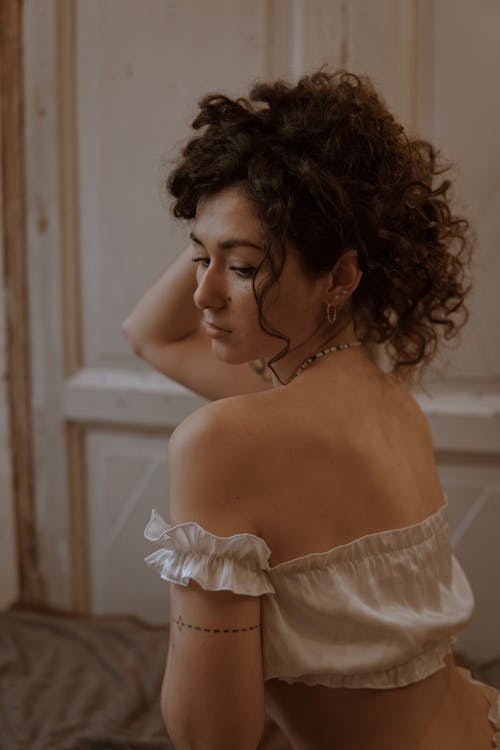 A woman with curly hair and a white top