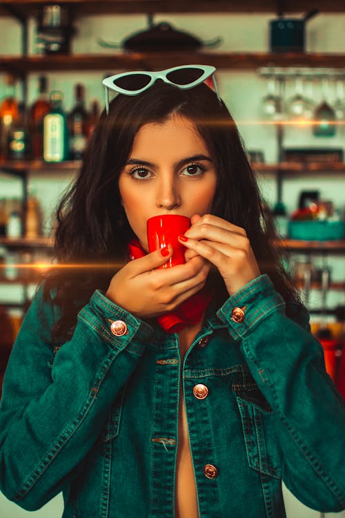 Close-up Photo of Woman Drinking from Red Coffee Cup