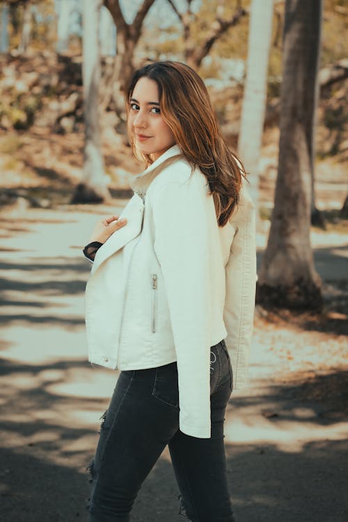 A woman in a white jacket and jeans