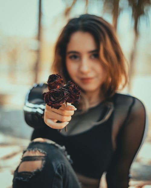 A woman holding a rose in her hand